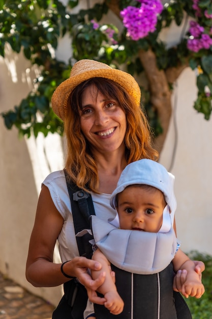 A mother walking with her baby through the town of Sa Tuna on the coast of Begur in summer, Girona on the Costa Brava of Catalonia in the Mediterranean