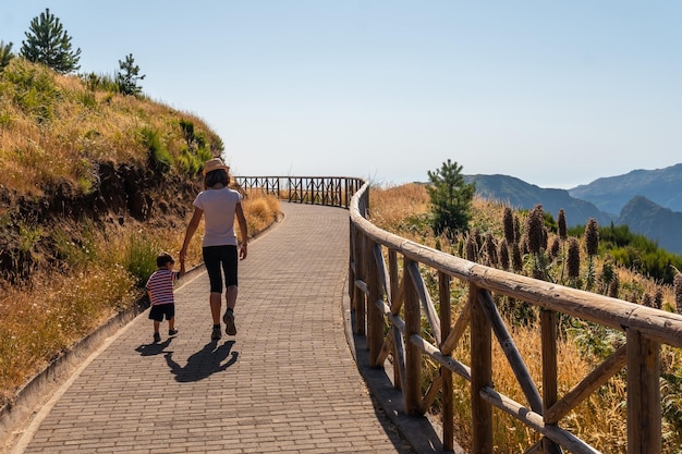 A mother walking with her son at the viewpoint of miradouro do paredao madeira portugal