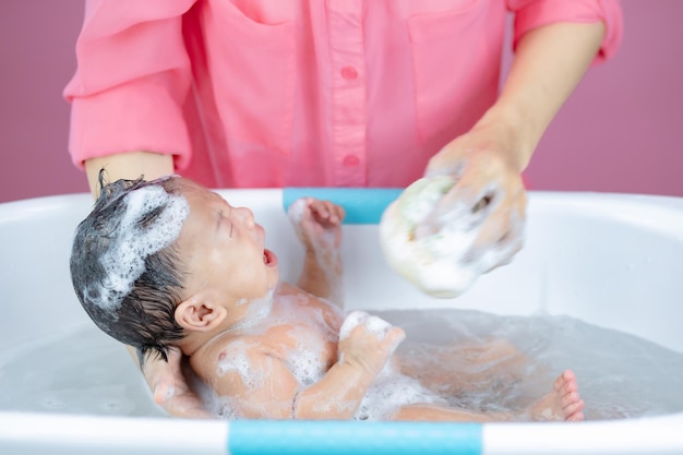 Mother Washing Baby pink background