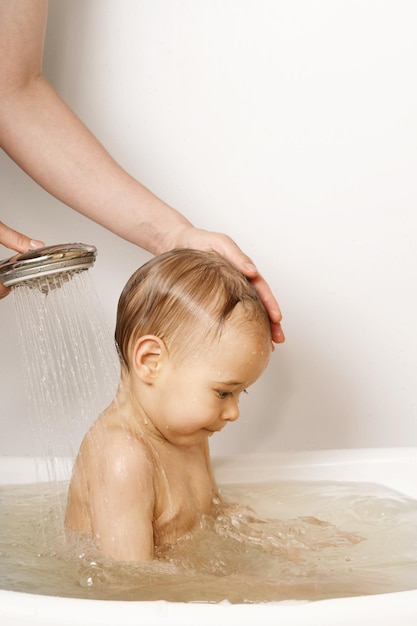 Mother washing and showering her little son