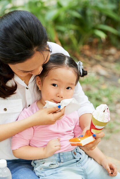 Mother wiping face of daughter