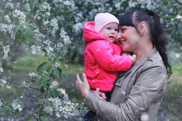 Mother with baby in apple garden