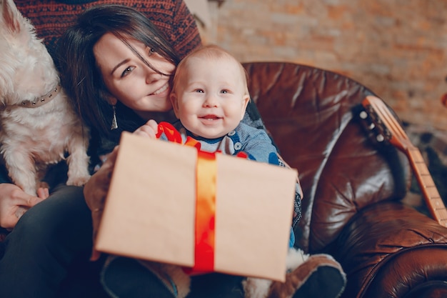 Foto madre con un bambino in braccio e questo con un regalo