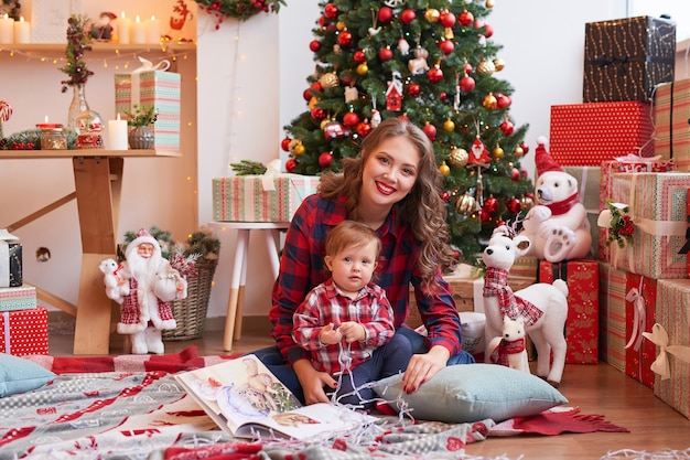 mother  with baby in the kitchen decorated for Christmas.