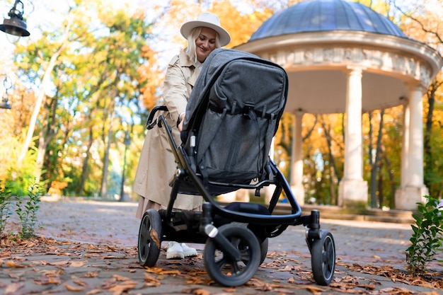 Mother with baby pram walking in park