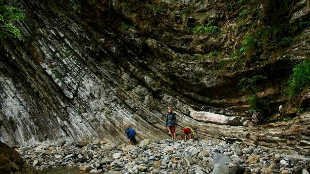 Photo mother with boys on stone river and jungles on the background creative exploring natural beautiful