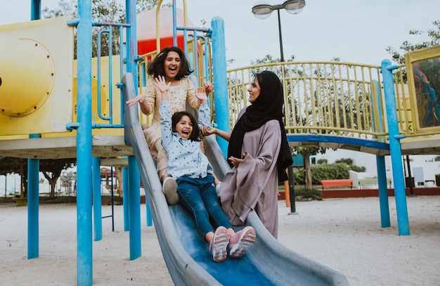 mother with cheerful daughters enjoying at park