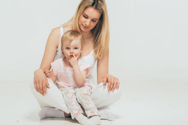 Mother with child baby portrait sitting floor studio