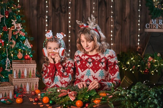 Mother with child girl near christmas tree.