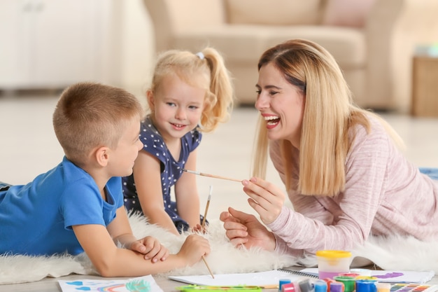 Mother with cute children painting, indoors
