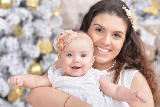 Mother with cute daughter posing in room