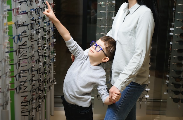 Mother with cute son. Family buy glasses