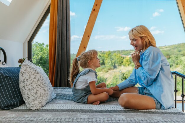 Mother with daughter in bedroom at home