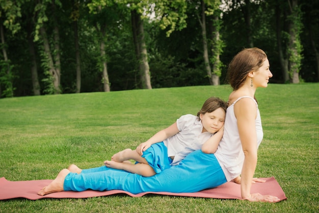 Mother with daughter doing yoga exercise