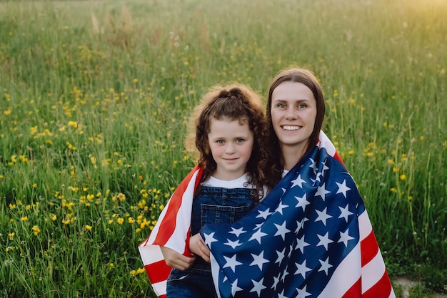 アメリカの国旗に包まれた娘の子供を持つ母