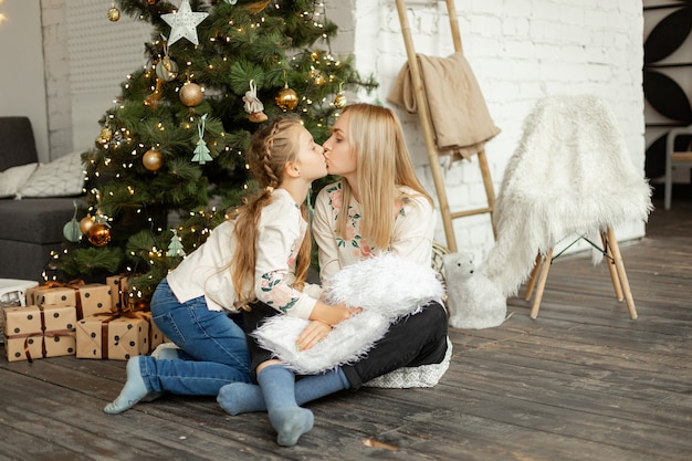 Mother with daughter near the Christmas tree