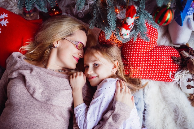 The mother with daughter near christmas tree