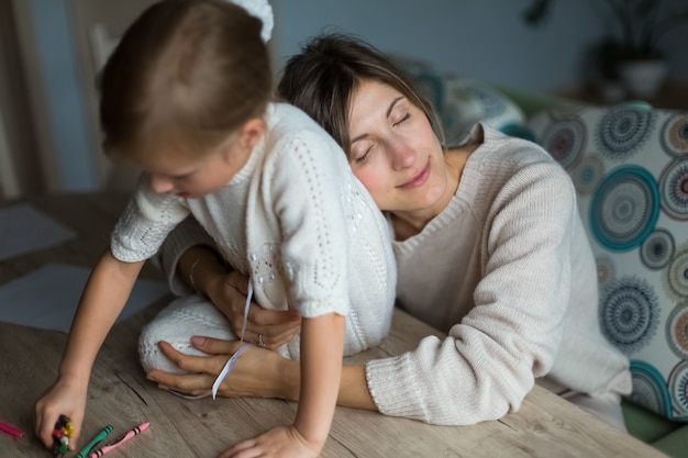 Mother with daughter, parental contact. girl sitting on the table. 