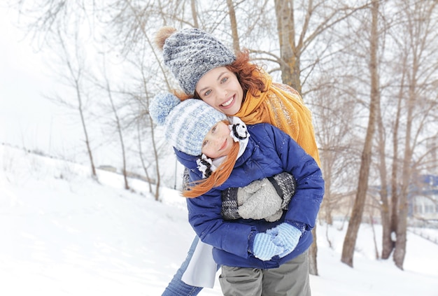 Mother with daughter playing in winter park