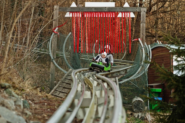 写真 娘と一緒の母はレールに電気そりに乗る