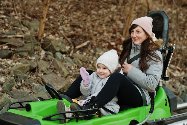 Mother with daughter ride electric sleigh on rails