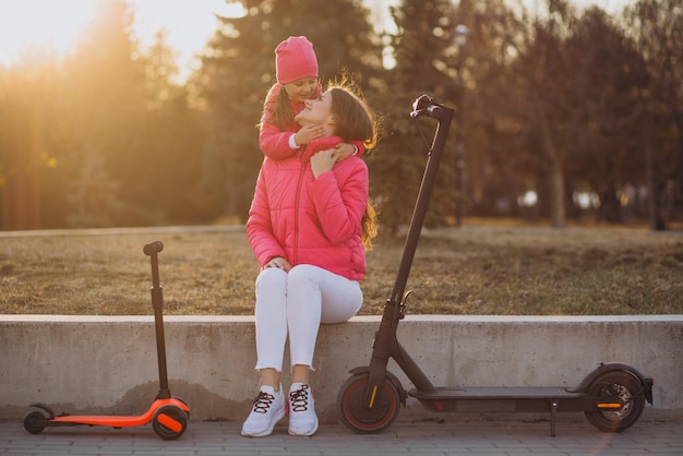 Mother with daughter riding electric scooter