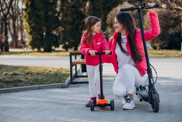 Mother with daughter riding electric scooter