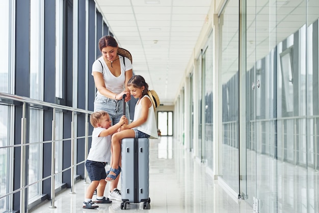 Mother with daughter and son Young traveler is on the entrance hall in the airport