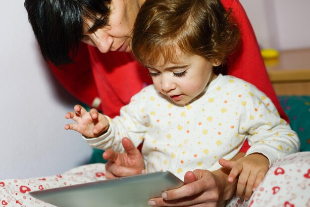 写真 母と娘がデジタルタブレットを使っている