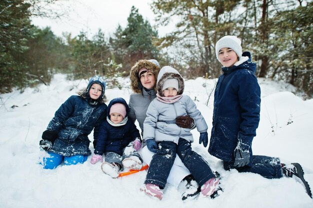 雪の中で冬の自然の屋外で 4 人の子供を持つ母