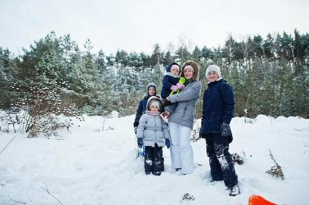 雪の中で冬の自然の屋外で 4 人の子供を持つ母