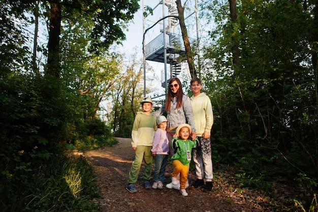 Mother with four kids against viewing tower at Brno Czech Republic Watchtower during sunset with trees