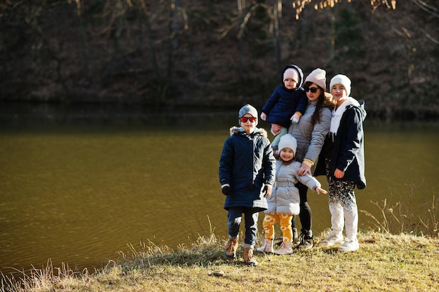 Mother with four kids in pound at early spring park