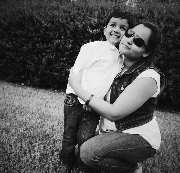 Photo mother with happy son on grassy field