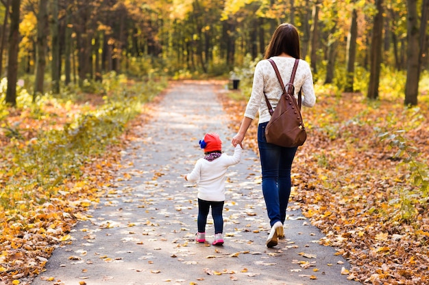 Mother with her baby. Mom and daughter in an autumn park.