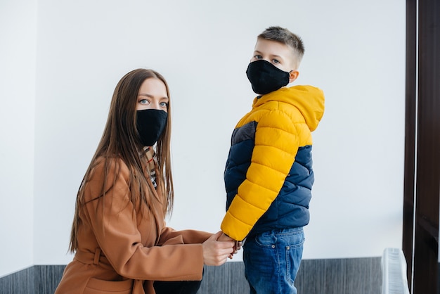 A mother with her child stands in a mask during the quarantine. Pandemic, coronavirus.