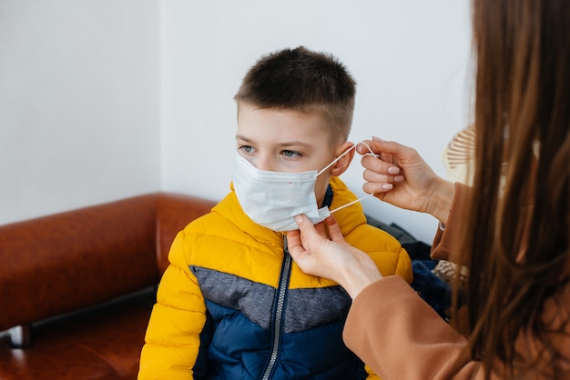 A mother with her child stands in a mask during the quarantine. Pandemic, coronavirus.