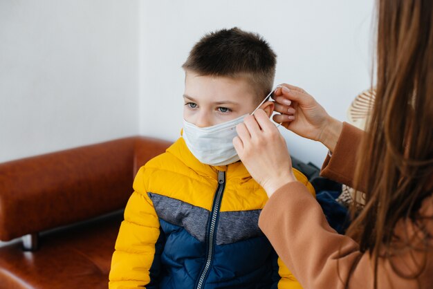 A mother with her child stands in a mask during the quarantine. Pandemic, coronavirus.