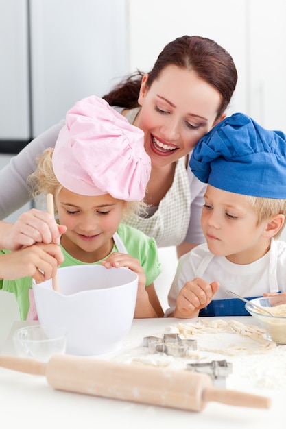 Mother with her children baking together in the kitchen