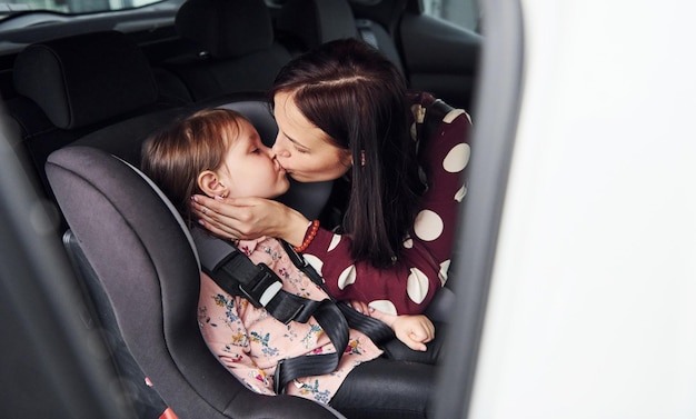 Mother with her daughter inside of modern automobile together