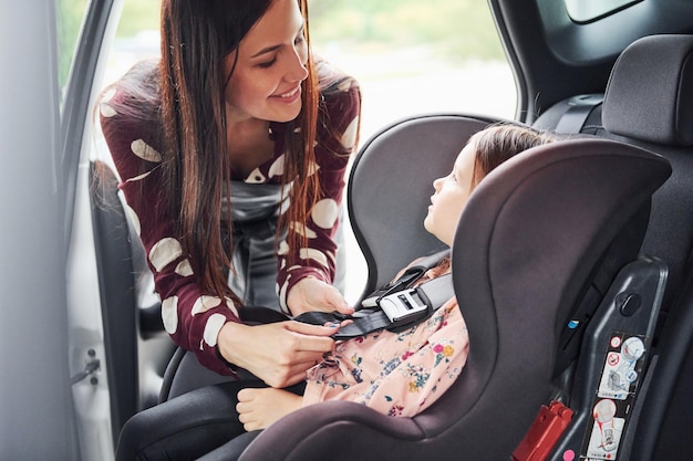 Mother with her daughter inside of modern automobile together