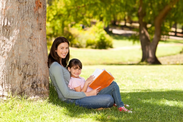 Mother with her daughter looking at their album photo