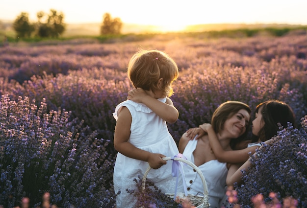 A mother with her daughters at sunset in the lavender field at sunset. Concept of International Women's Day