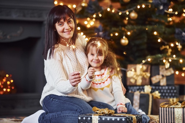 Mother with her little daughter celebrating christmas with presents.