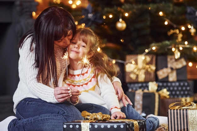 プレゼントでクリスマスを祝う彼女の小さな娘と母。