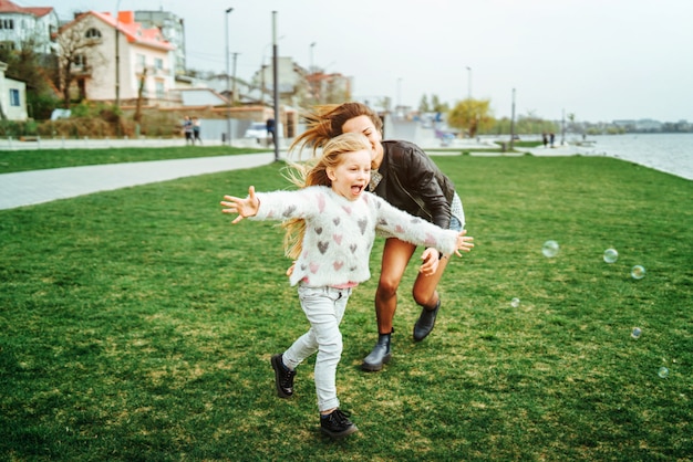 Mother with her little daughter have fun in the park