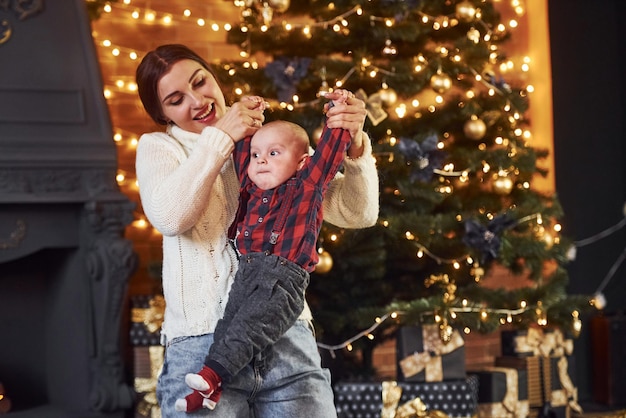 Mother with her little son celebrating new year and christmas holidays indoors.