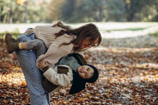 Mother with her little son walking in autumnal park