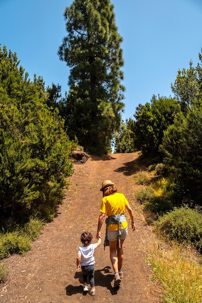 A mother with her son walking up a hill on the La Llania trekking trail in El Hierro Canary Islands