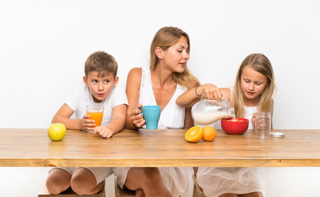 Mother with her two children having breakfast